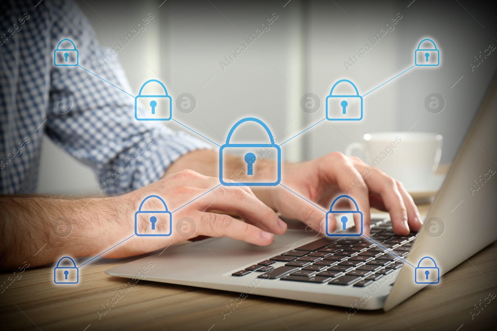 Image of Information security. Young man using laptop at table indoors, closeup