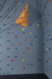 Photo of Climbing wall with holds in gym. Extreme sport