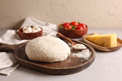 Photo of Pizza dough and products on gray table