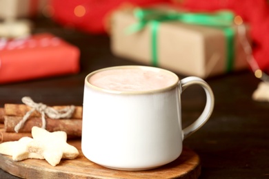 Photo of Delicious cocoa drink in white cup with cookies on black table