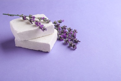 Photo of Hand made soap bars with lavender flowers on violet background, space for text