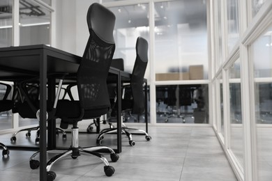 Photo of Comfortable office chairs and tables in meeting room