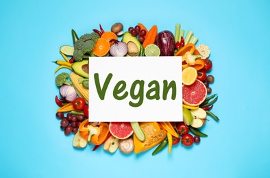 Image of Paper card with word Vegan, fresh vegetables and fruits on turquoise background, top view
