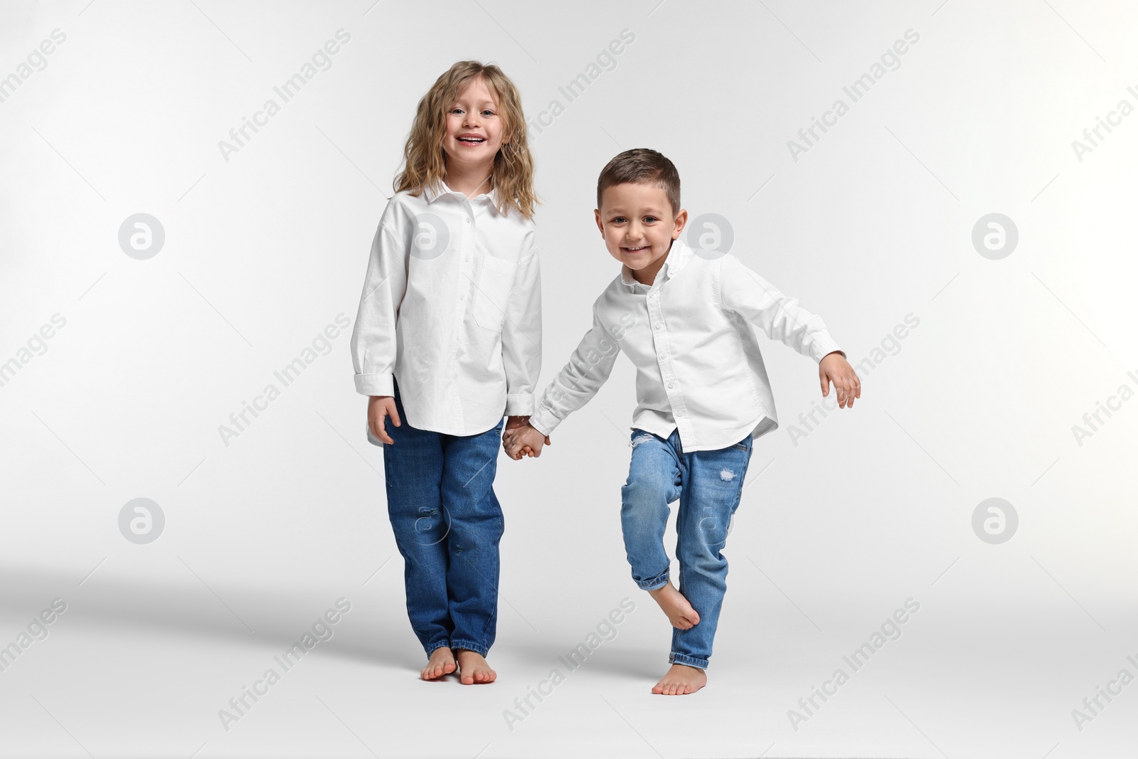 Photo of Cute little children on white background. Happy family