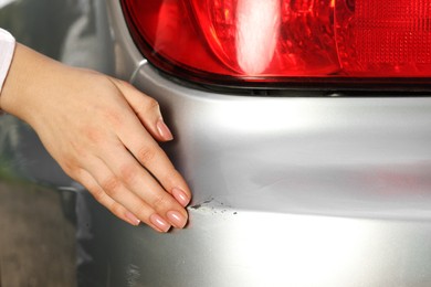 Photo of Woman near car with scratch outdoors, closeup view