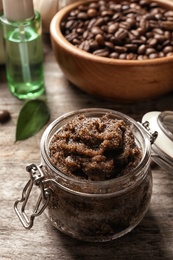 Photo of Jar with handmade natural body scrub on wooden table