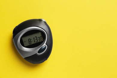 Photo of Digital timer on yellow background, top view. Space for text