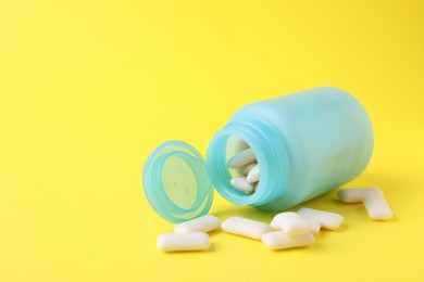 Photo of Jar with chewing gums on yellow background. Space for text