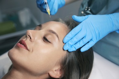 Photo of Beautiful woman getting facial injection in salon