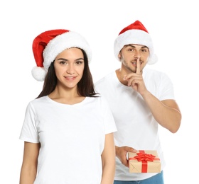 Photo of Young man giving gift box to girlfriend on white background. Happy couple celebrating Christmas