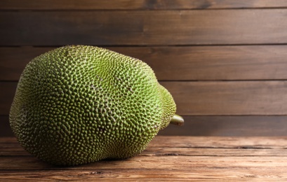 Photo of Fresh exotic jackfruit on wooden table. Space for text