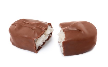 Photo of Halves of delicious milk chocolate candy bar with coconut filling on white background