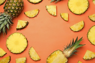 Photo of Flat lay composition with cut and fresh juicy pineapples on color background, space for text