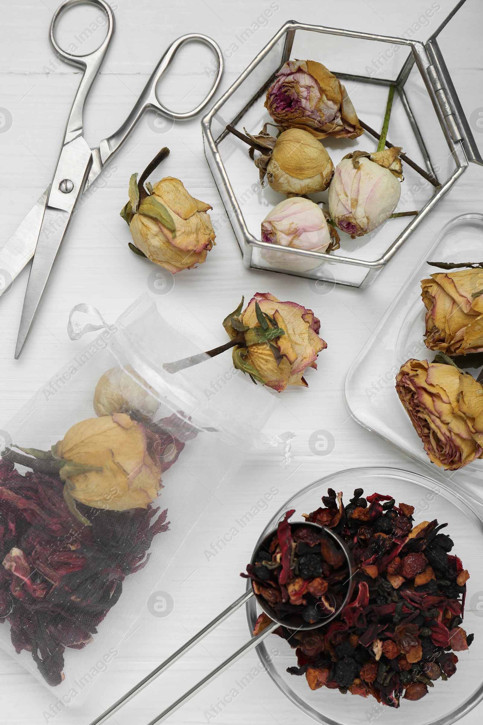 Photo of Scented sachet with dried flowers and scissors on white table, flat lay