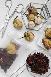 Scented sachet with dried flowers and scissors on white table, flat lay