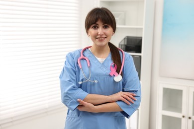 Photo of Mammologist with pink ribbon in hospital. Breast cancer awareness