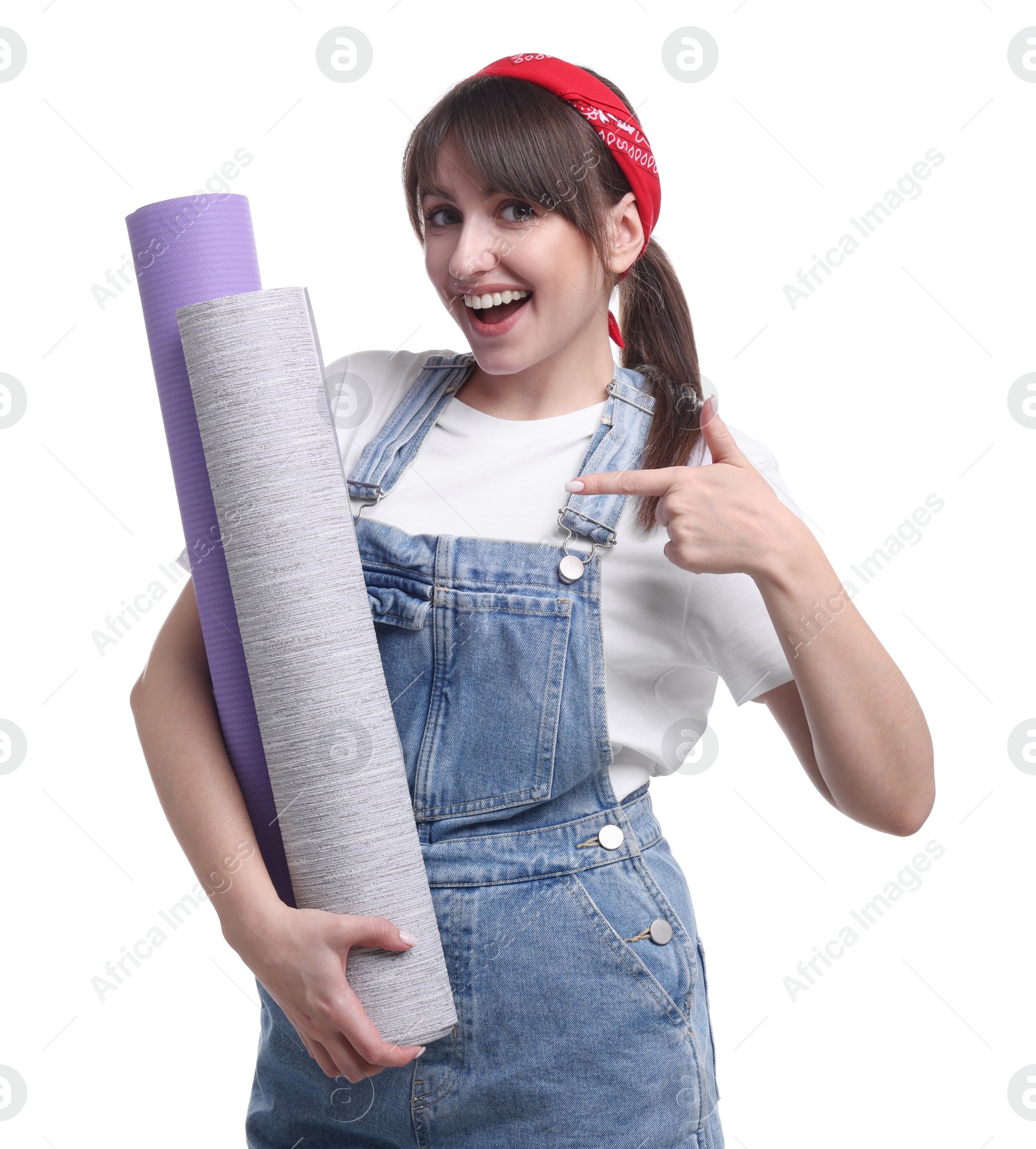 Photo of Beautiful woman pointing at wallpaper rolls on white background