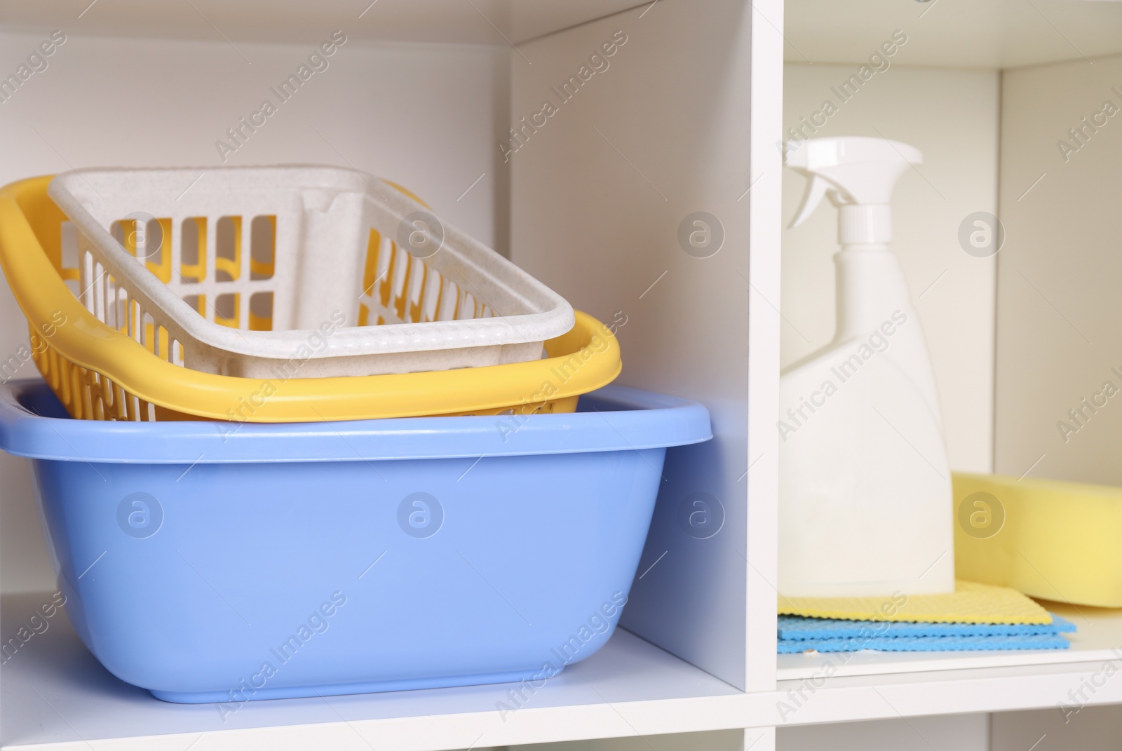 Photo of Detergent, baskets and different cleaning tools on shelves