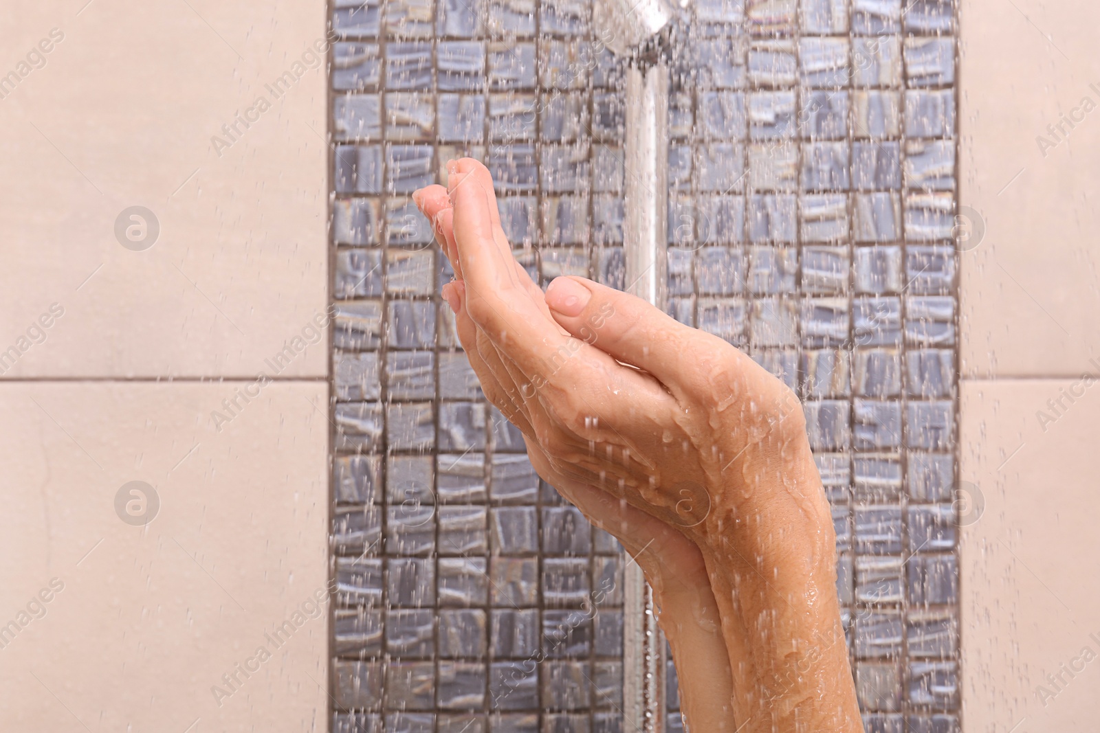 Photo of Young woman taking shower, focus on hands