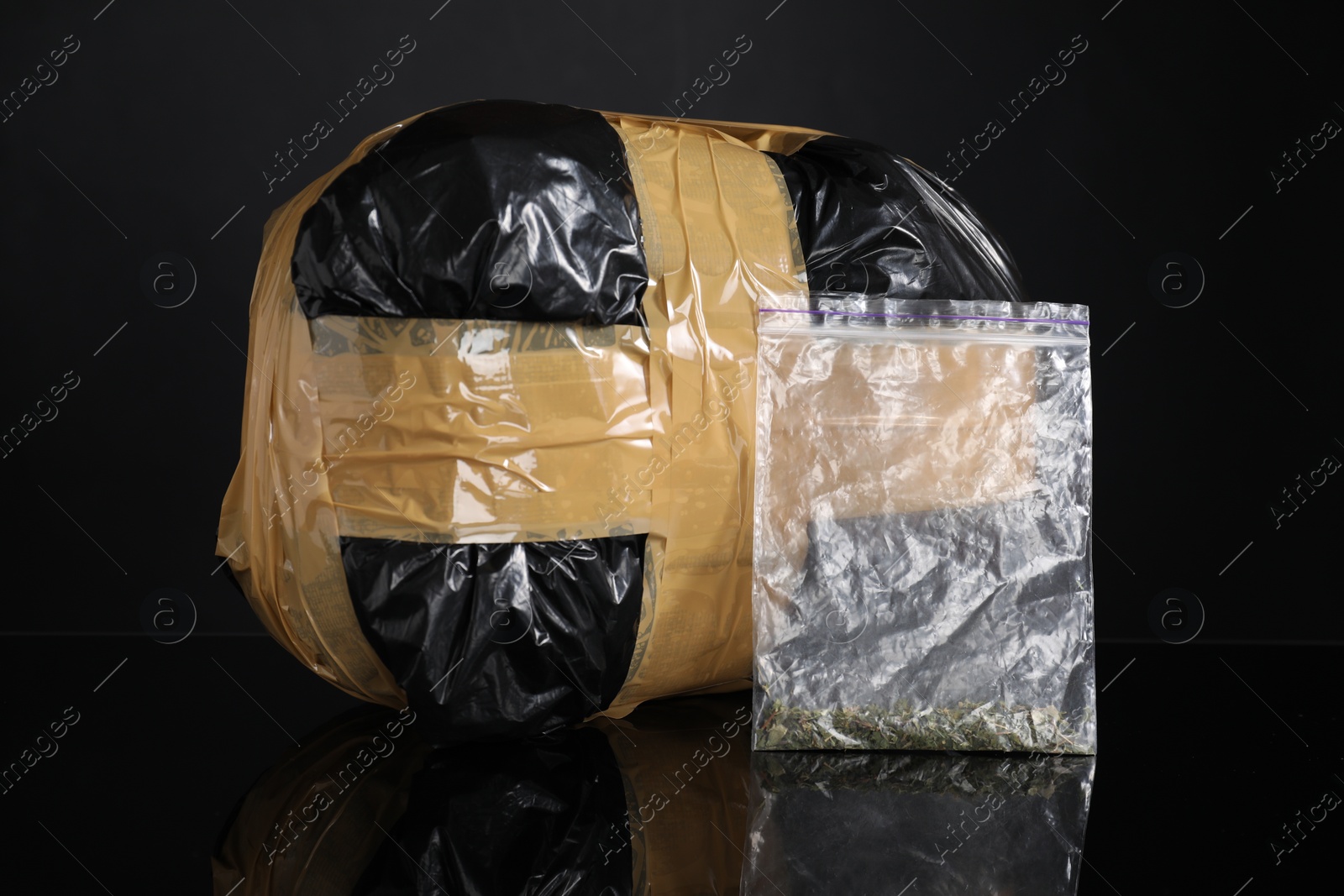 Photo of Smuggling and drug trafficking. Packages with narcotics on black mirror surface