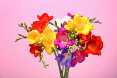 Photo of Bouquet with beautiful freesia flowers on color background