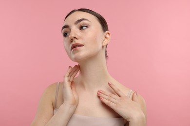 Photo of Beautiful woman touching her neck on pink background