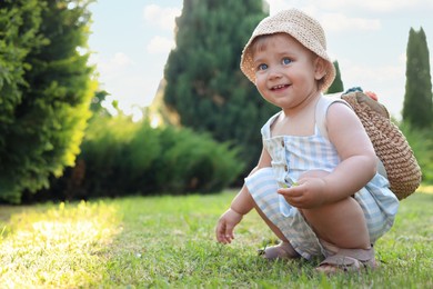 Photo of Cute little girl in stylish clothes with knitted backpack outdoors on sunny day. Space for text