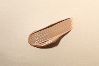 Photo of Swatch of skin foundation on beige background, top view