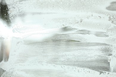 Cleaning foam on window glass, closeup view