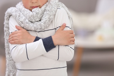 Photo of Sad little boy suffering from cold on blurred background