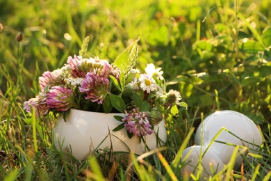 Ceramic mortar with pestle, different wildflowers and herbs green grass outdoors