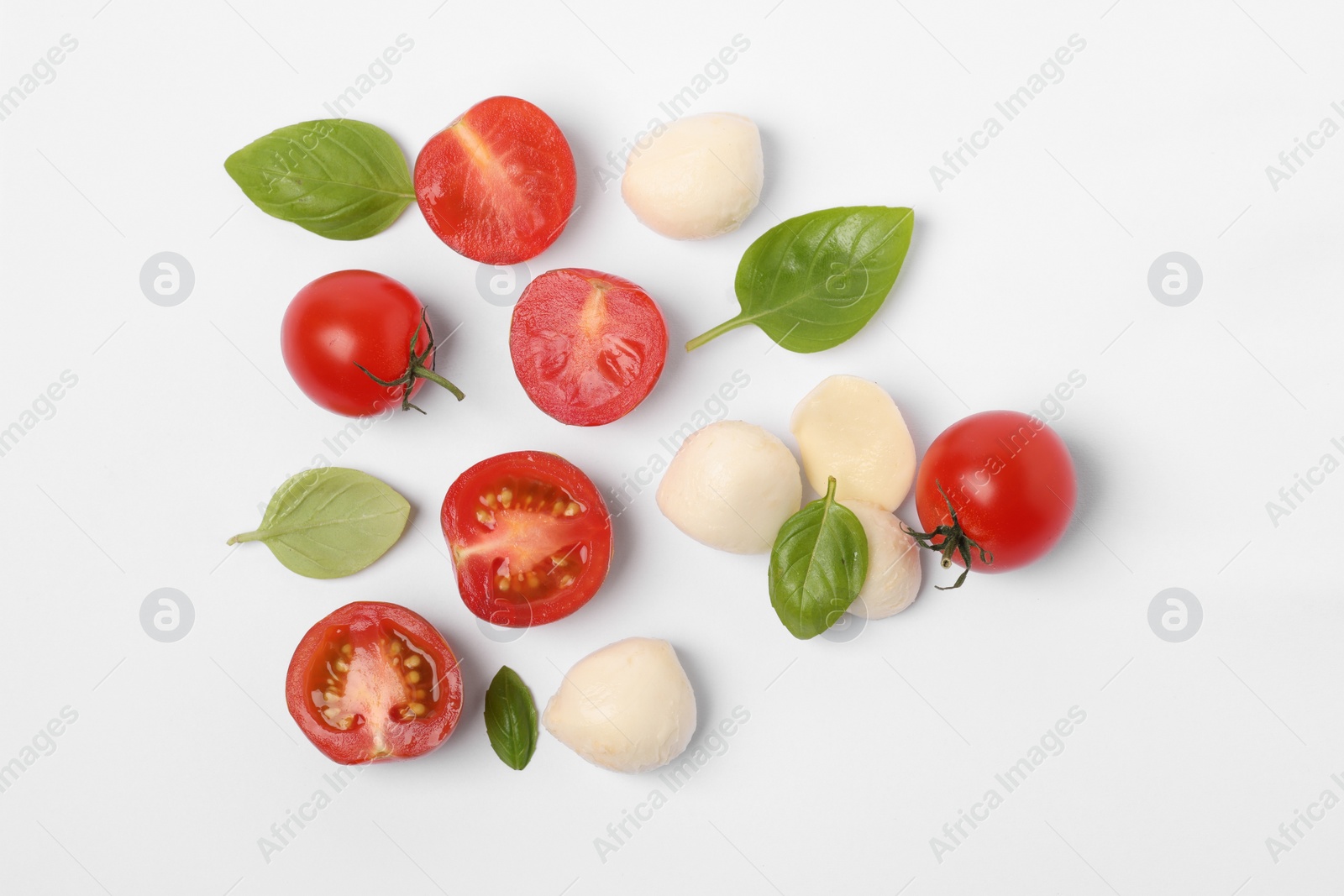 Photo of Mozzarella, tomatoes and basil on white background, flat lay. Caprese salad ingredients