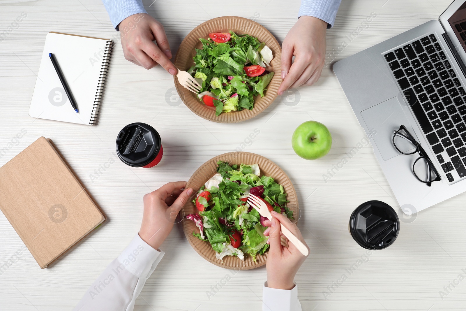 Photo of Office employees having business lunch at workplace, top view