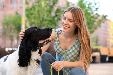 Young woman with her English Springer Spaniel dog outdoors