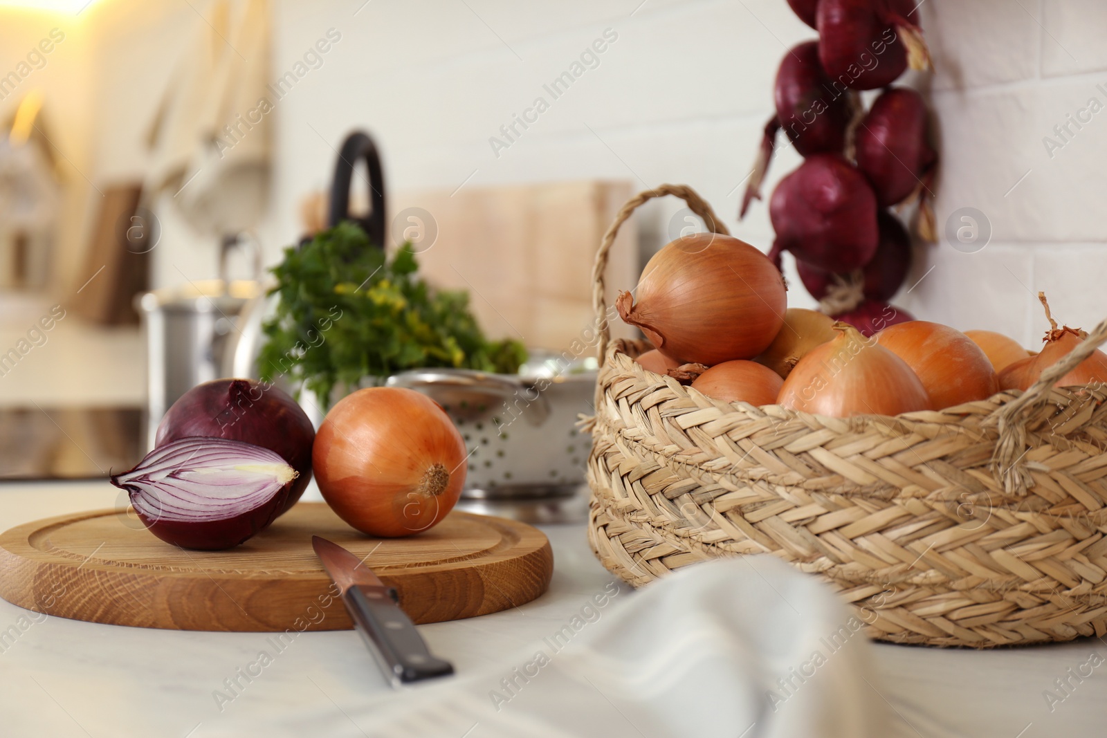 Photo of Fresh cut and whole onions on countertop in modern kitchen