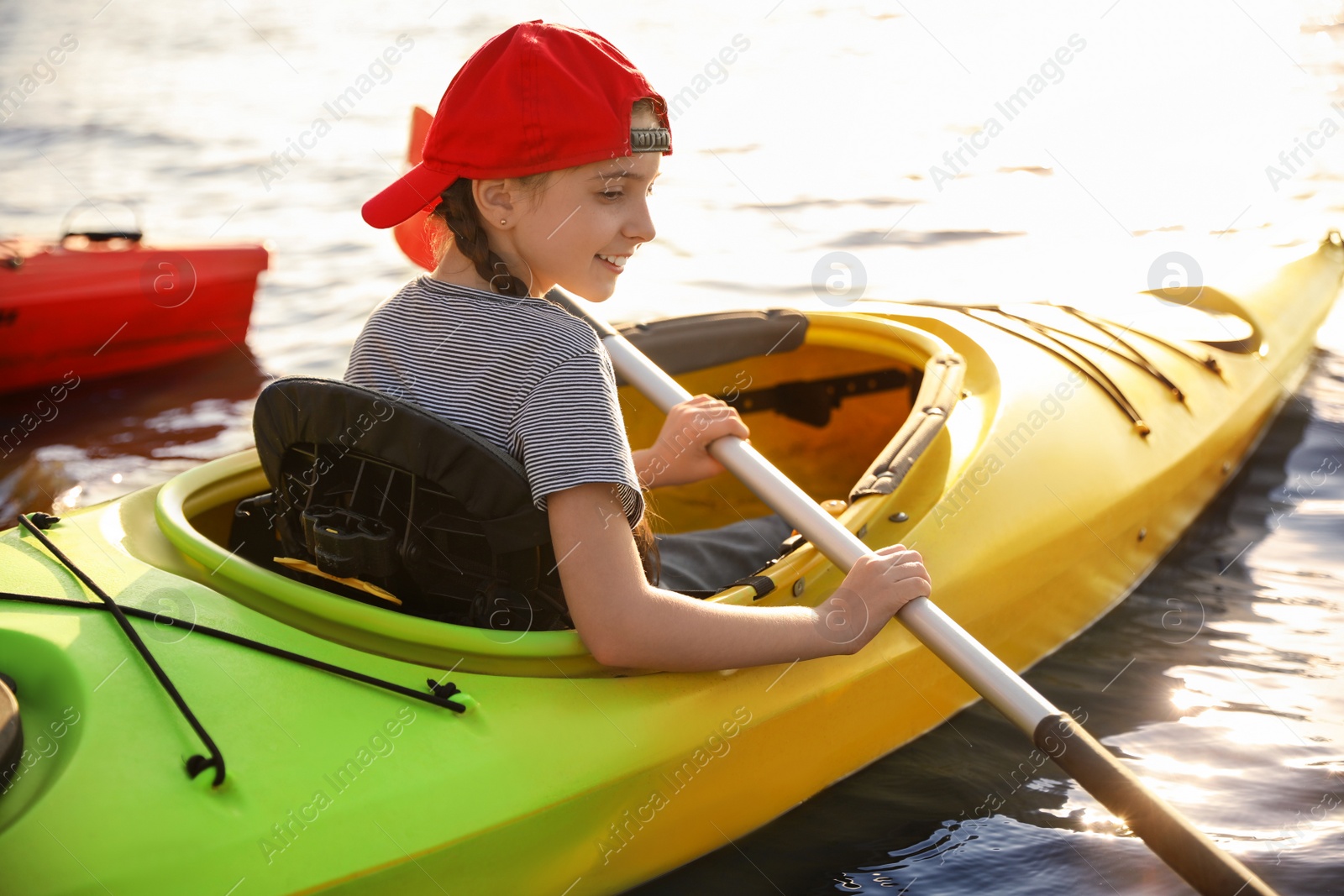 Photo of Happy little girl kayaking on river. Summer camp activity