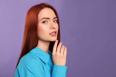Photo of Beautiful woman with red dyed hair on purple background, space for text