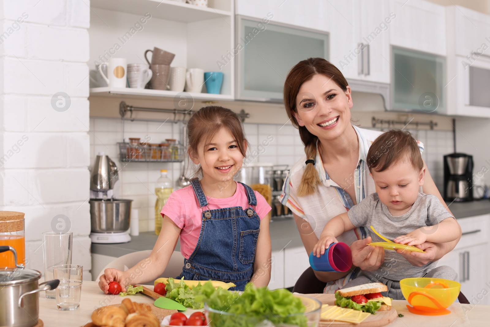 Photo of Housewife preparing dinner with her children on kitchen