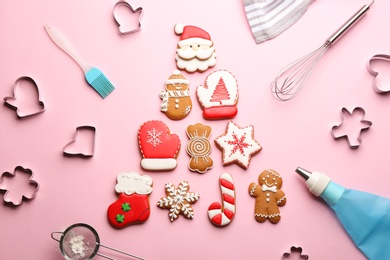 Photo of Christmas tree made of delicious gingerbread cookies surrounded by kitchen utensils on pink background, flat lay