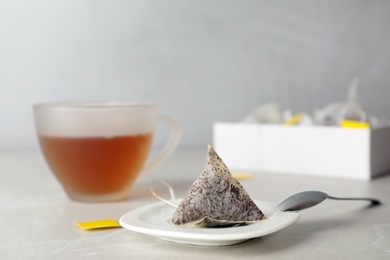 Photo of Saucer with used tea bag on table