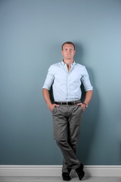 Confident handsome young man on color background