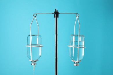 IV infusion set on pole against light blue background