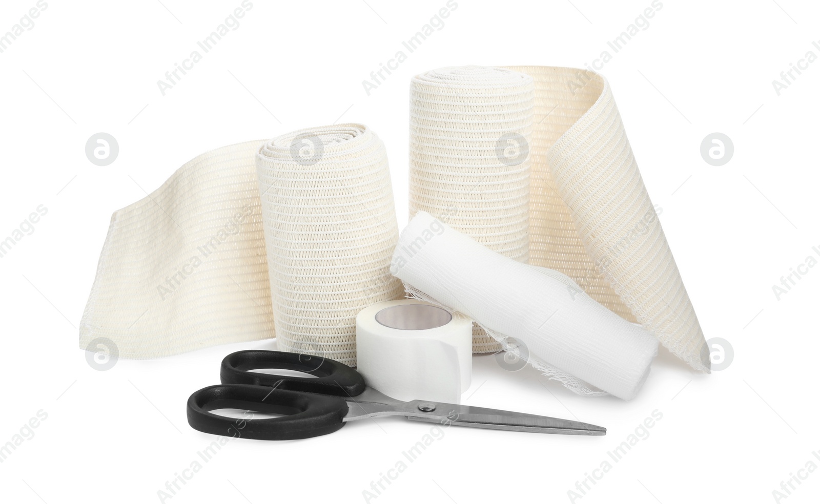 Photo of Medical bandage rolls, sticking plaster and scissors on white background