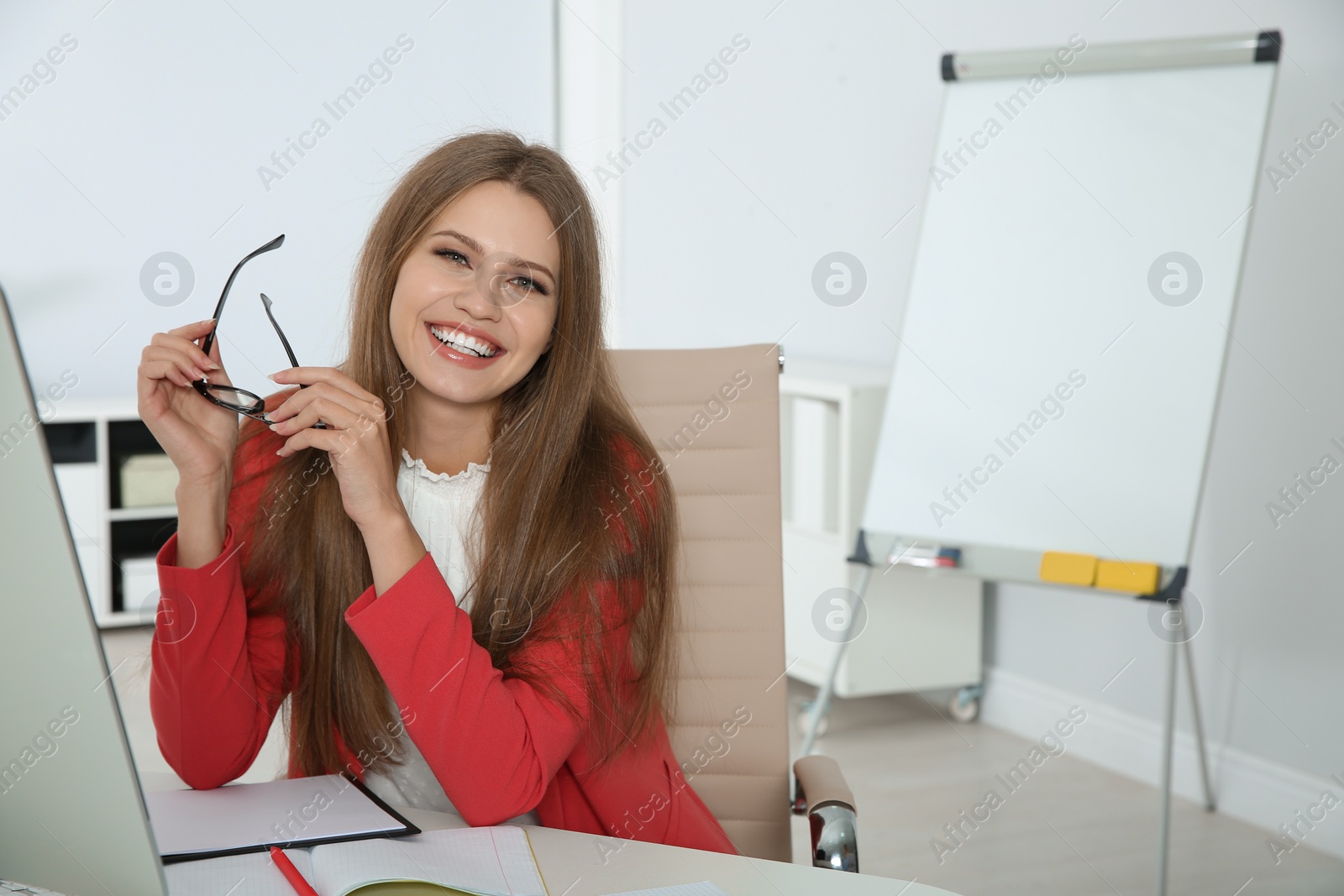 Photo of Portrait of young businesswoman laughing at workplace. Space for text