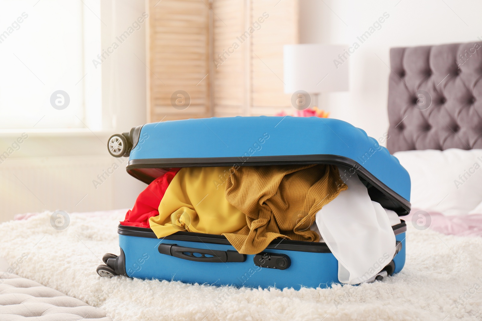 Photo of Packed travel suitcase on bed