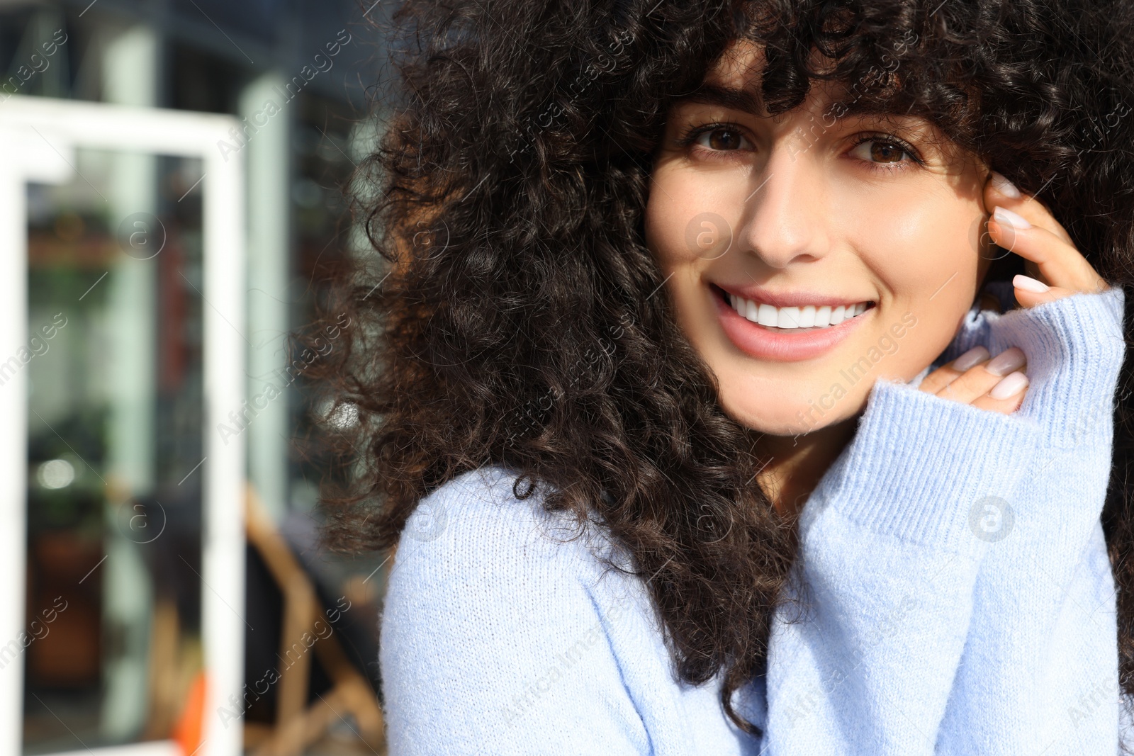 Photo of Happy young woman in stylish light blue sweater outdoors