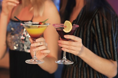 Photo of Young women with tasty martini cocktails, closeup