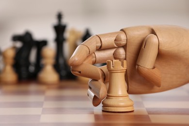 Photo of Robot moving chess piece on board against light background, closeup. Wooden hand representing artificial intelligence