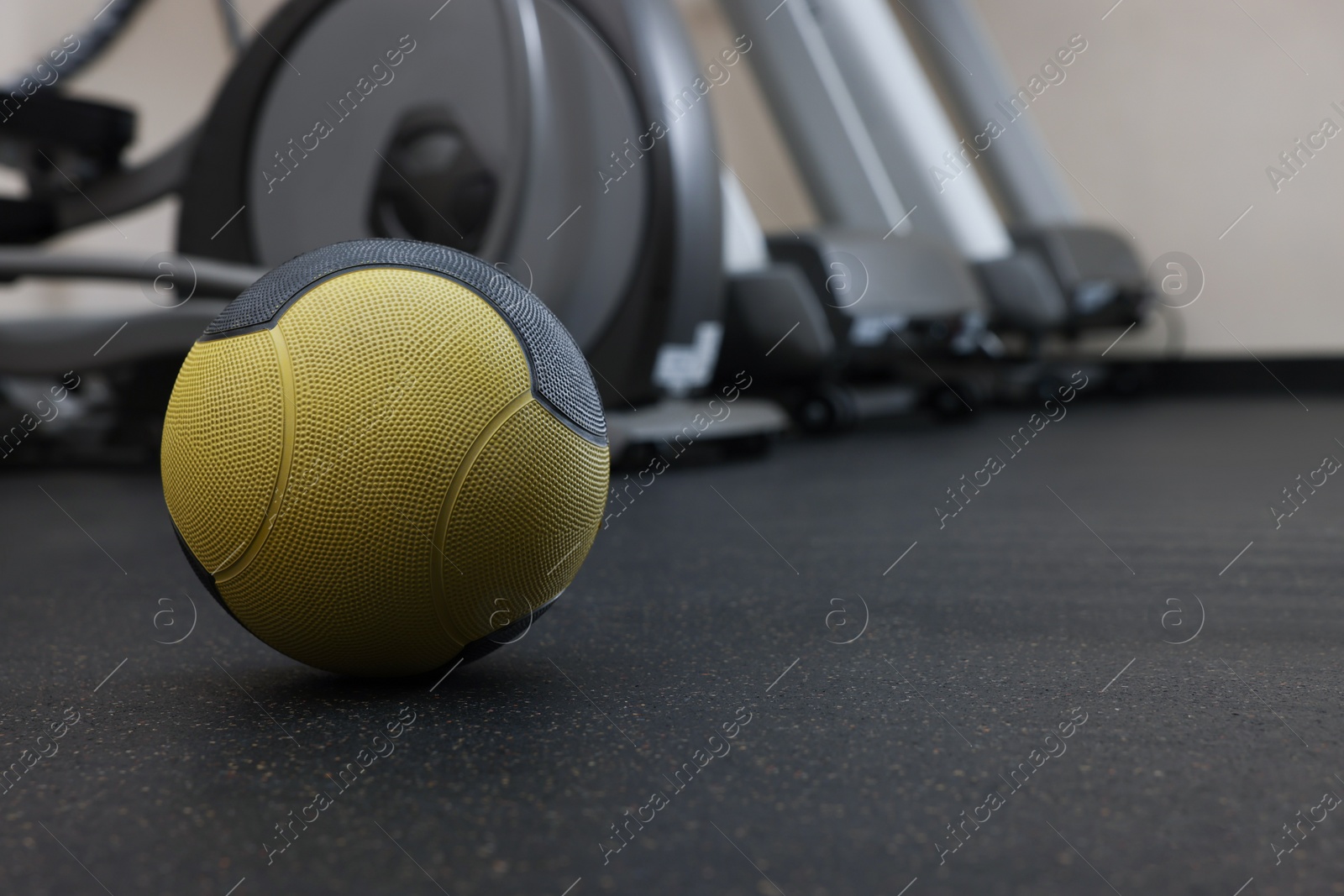 Photo of Yellow medicine ball on floor in gym, space for text