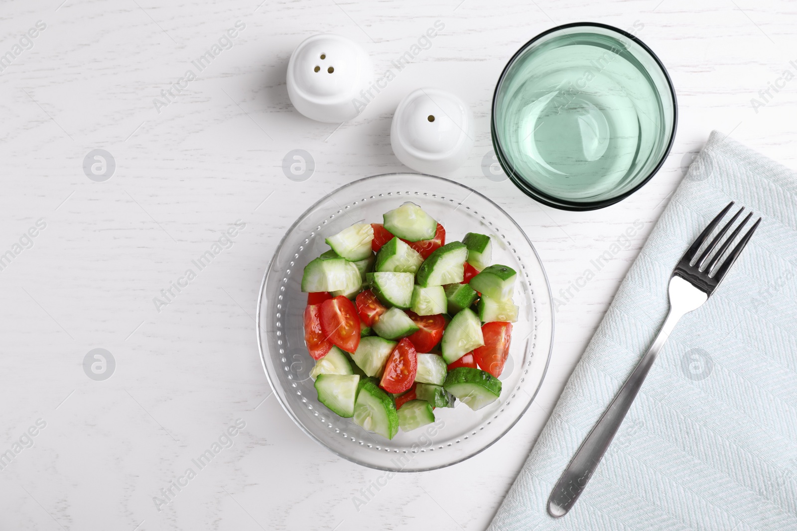 Photo of Flat lay composition with delicious fresh cucumber tomato salad on table, space for text